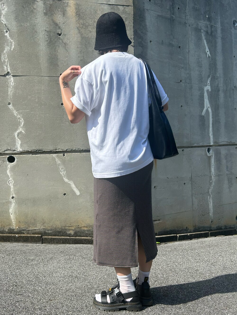 ブラック系のサンダル、ホワイト系のTシャツ/カットソー、ブラウン系のワンピースを着用したレディースの夏コーディネートの3枚目の写真