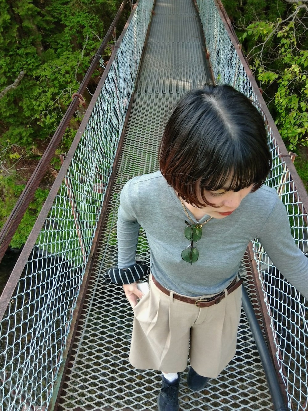 ブラック系のバックパック/リュック、ブラック系のスニーカー、グレー系のTシャツ/カットソーを着用したレディースの春コーディネートの2枚目の写真