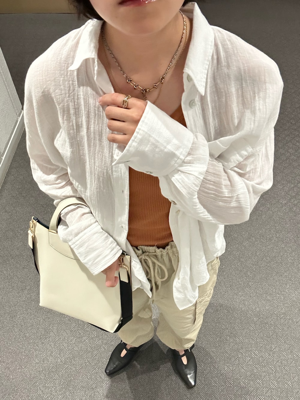 ブラック系のパンプス、ベージュ系のカーゴパンツ、ホワイト系のシャツ/ブラウスを着用したレディースの夏コーディネートの3枚目の写真
