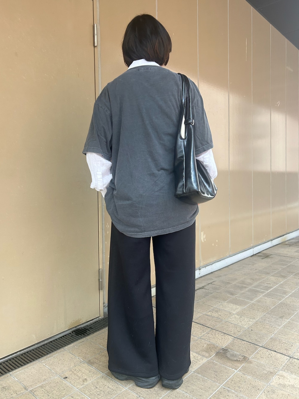 グレー系のTシャツ/カットソー、ブラック系のスニーカー、ホワイト系のシャツ/ブラウスを着用したレディースの秋コーディネートの2枚目の写真