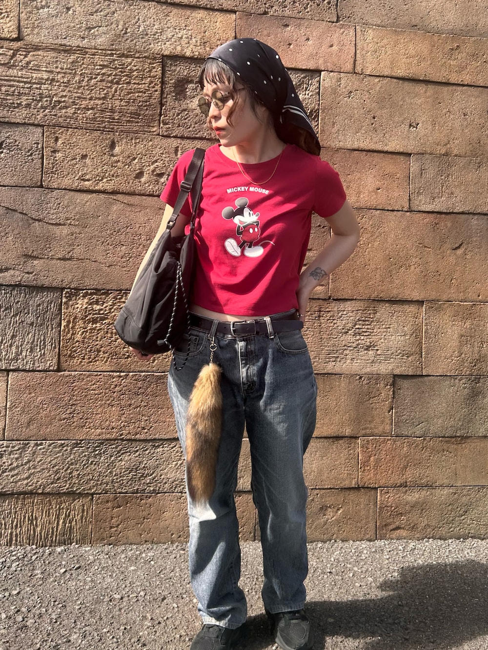 レッド系のTシャツ/カットソー、ブラック系のスニーカー、ブラック系のデニムパンツを着用したレディースの春コーディネートの4枚目の写真