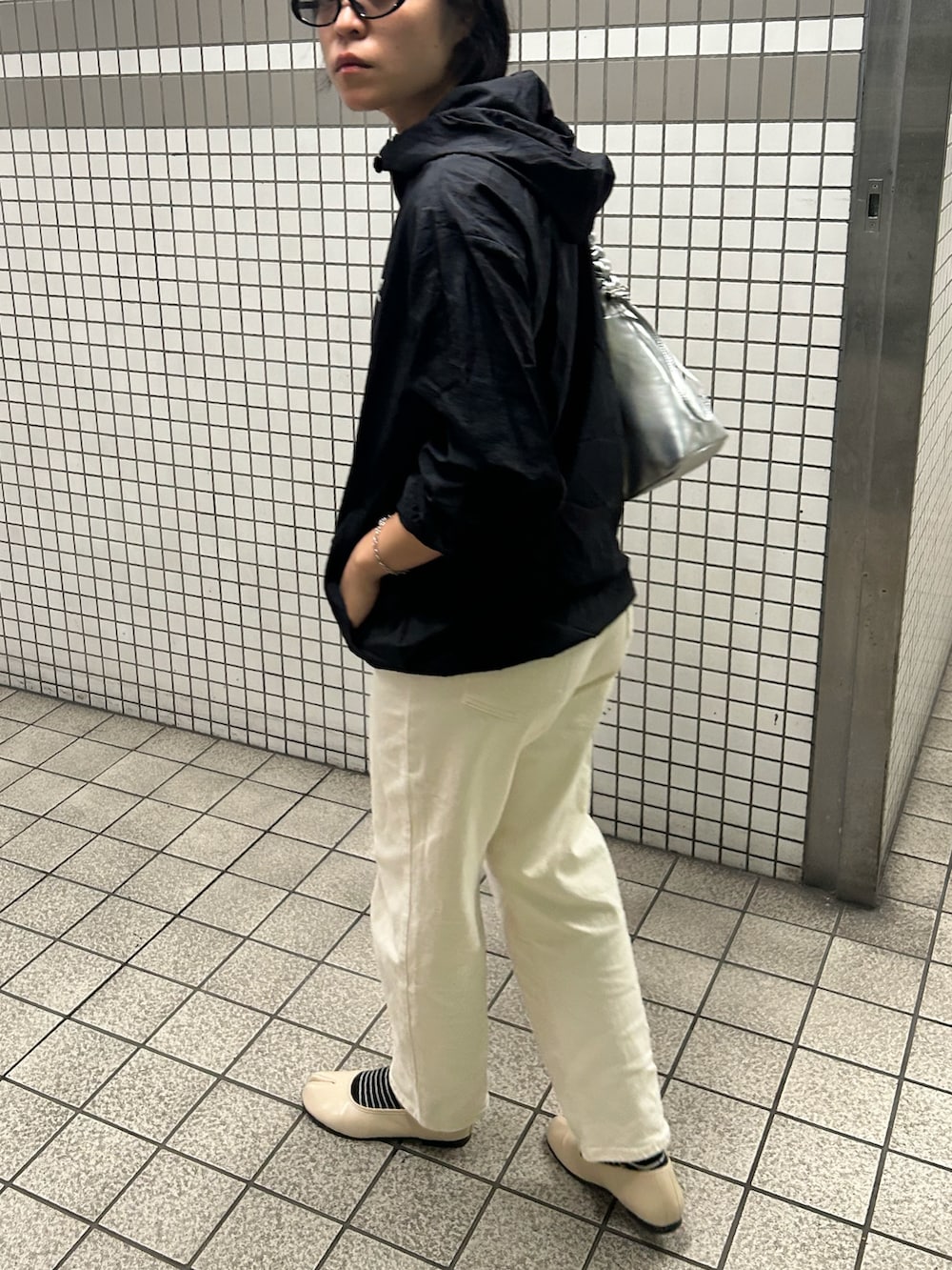 シルバー系のショルダーバッグ、ブラック系のジャケット/アウター、ホワイト系のデニムパンツを着用したレディースの秋コーディネートの2枚目の写真