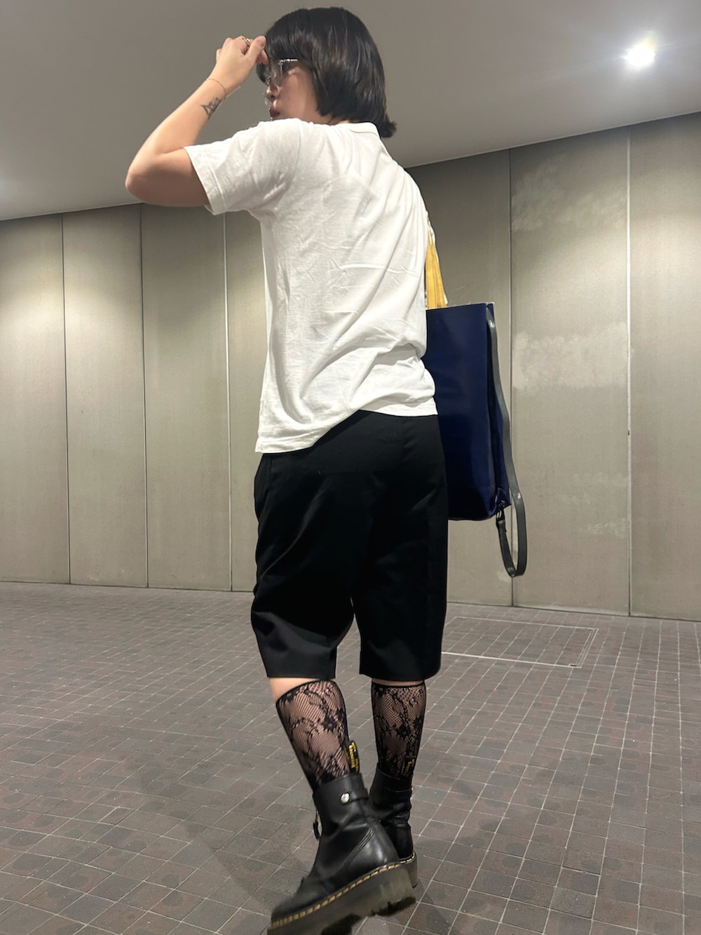 ホワイト系のTシャツ/カットソー、ブラック系のブーツ、ブラック系のパンツを着用したレディースの秋コーディネートの2枚目の写真