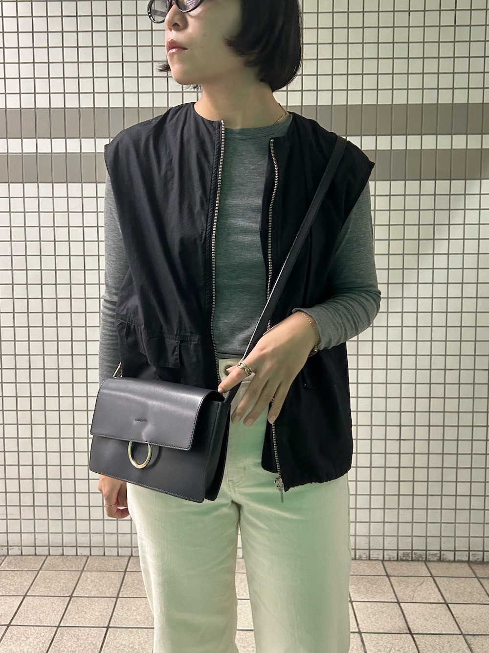 ブラック系のパンプス、ブラック系のベスト、グレー系のTシャツ/カットソーを着用したレディースの秋コーディネートの2枚目の写真