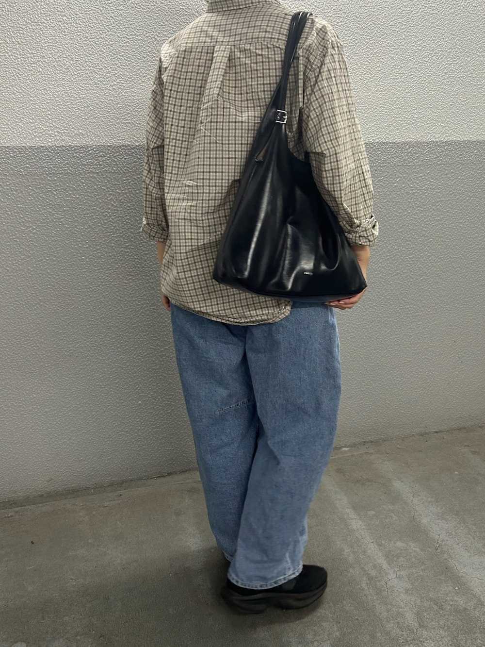ブルー系のデニムパンツ、ブラック系のスニーカー、ベージュ系のシャツ/ブラウスを着用したレディースの秋コーディネートの2枚目の写真