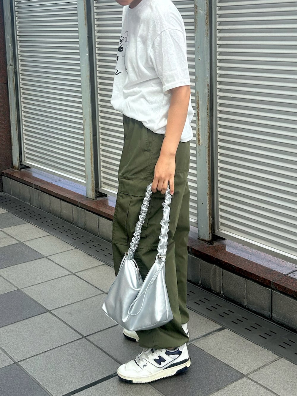 シルバー系のショルダーバッグ、ホワイト系のスニーカー、ホワイト系のTシャツ/カットソーを着用したレディースの秋コーディネートの2枚目の写真