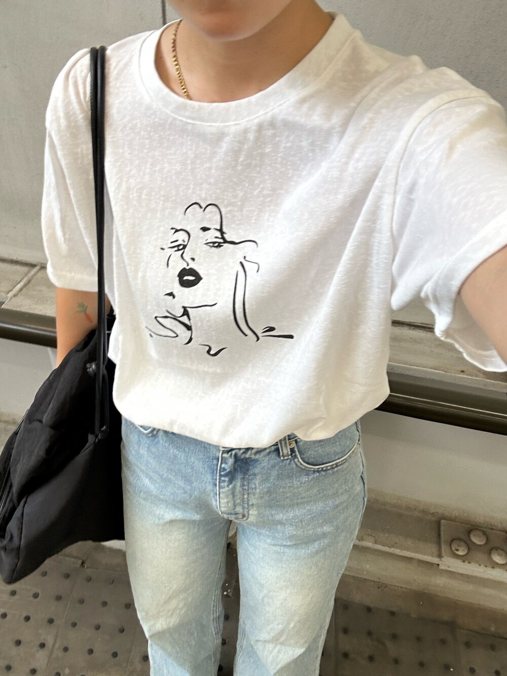 ホワイト系のTシャツ/カットソー、ブルー系のデニムパンツ、ブラック系のショルダーバッグを着用したレディースの夏コーディネートの2枚目の写真