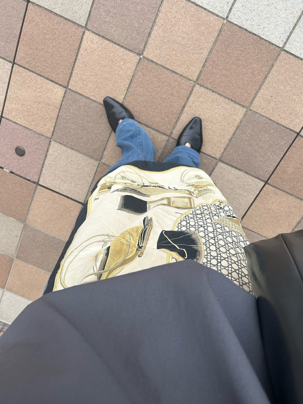 グレー系のポロシャツ、ブラック系のパンプス、ブラック系のバッグを着用したレディースの夏コーディネートの3枚目の写真