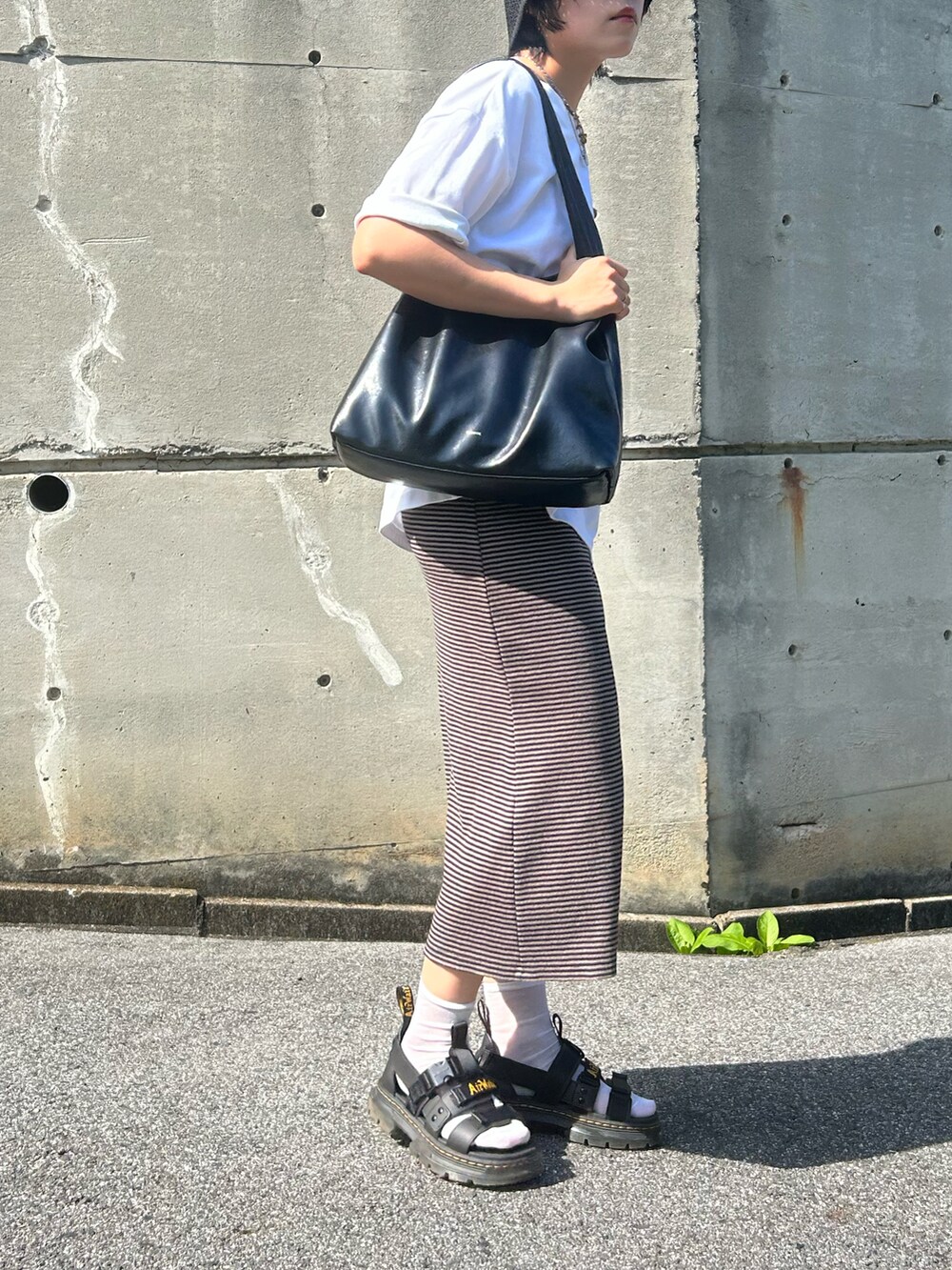 ブラック系のサンダル、ホワイト系のTシャツ/カットソー、ブラウン系のワンピースを着用したレディースの夏コーディネートの2枚目の写真