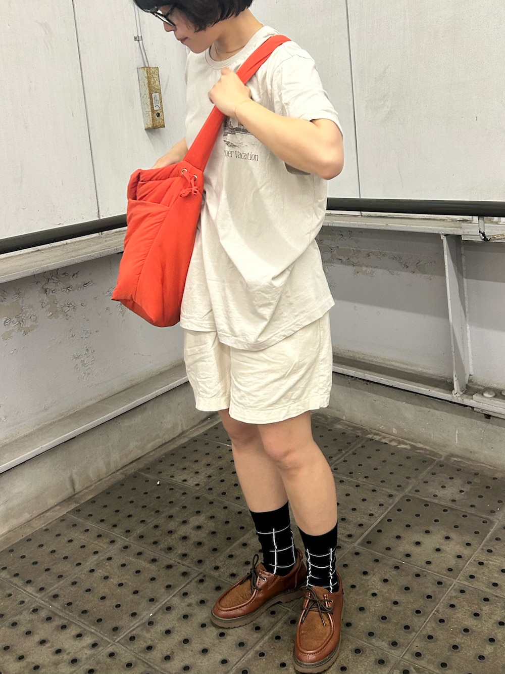 オレンジ系のトートバッグ、ベージュ系のTシャツ/カットソー、ホワイト系のパンツを着用したレディースの秋コーディネートの2枚目の写真