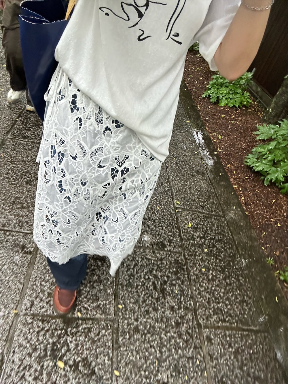 ホワイト系のスカート、ホワイト系のTシャツ/カットソー、ブルー系のデニムパンツを着用したレディースの夏コーディネートの3枚目の写真