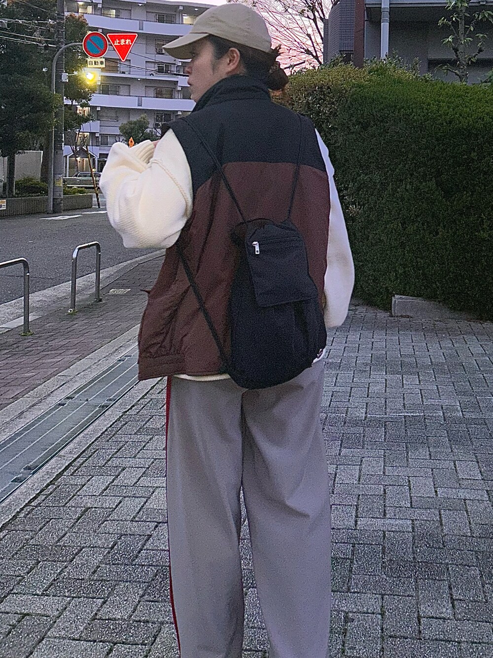 グレー系のその他パンツ、ホワイト系のニット/セーター、ベージュ系のスニーカーを着用したレディースの春コーディネートの4枚目の写真