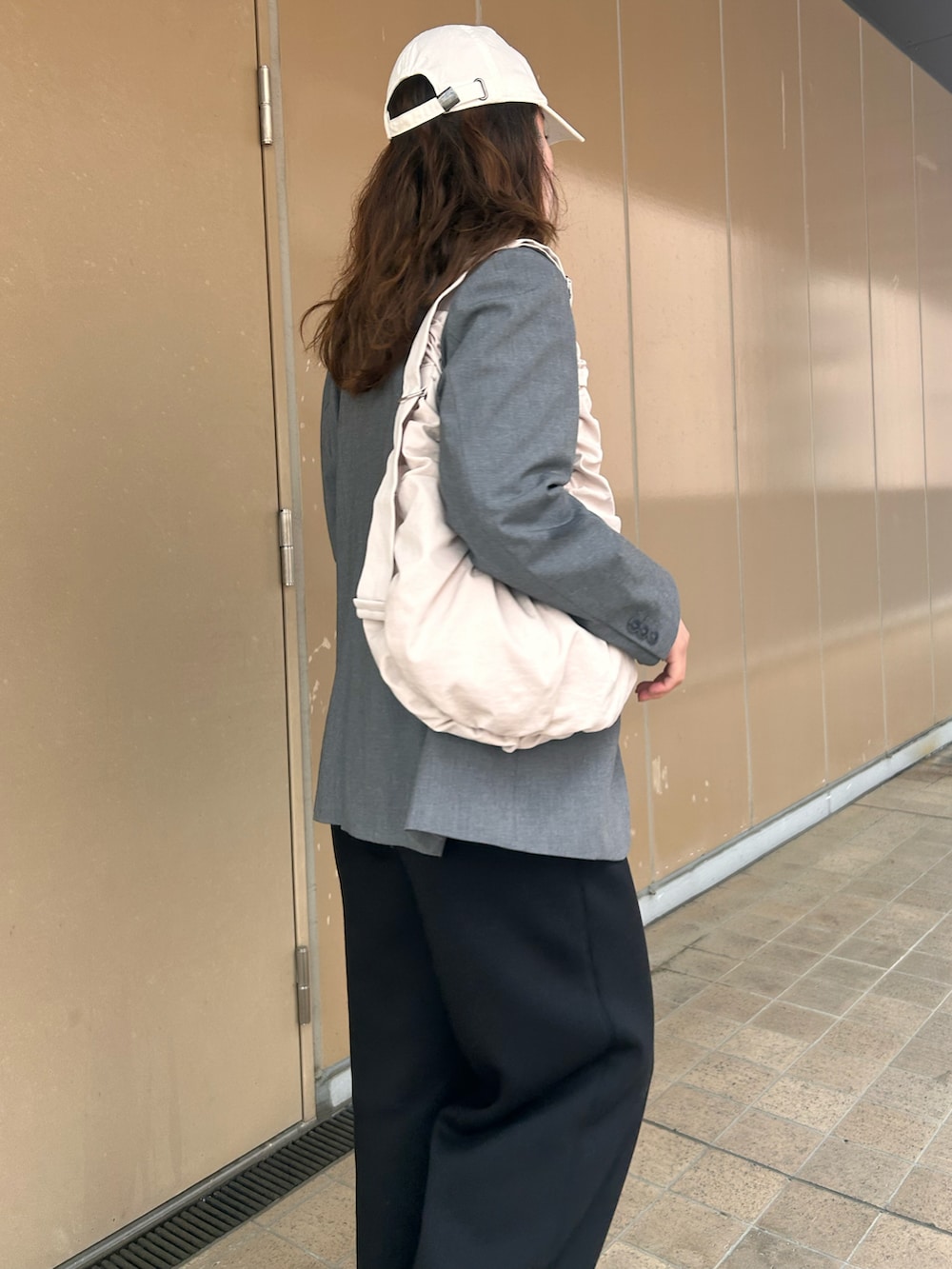 ブラック系のスニーカー、グレー系のテーラードジャケット、ブラック系のスウェットパンツを着用したレディースの春コーディネートの3枚目の写真