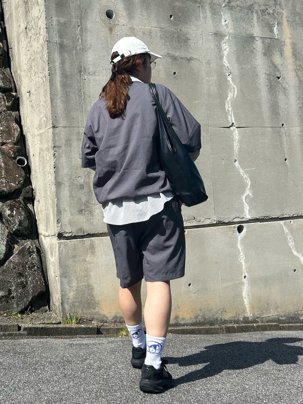 ブラック系のスニーカー、ホワイト系のシャツ/ブラウス、ブラック系のバッグを着用したレディースの春コーディネートの2枚目の写真