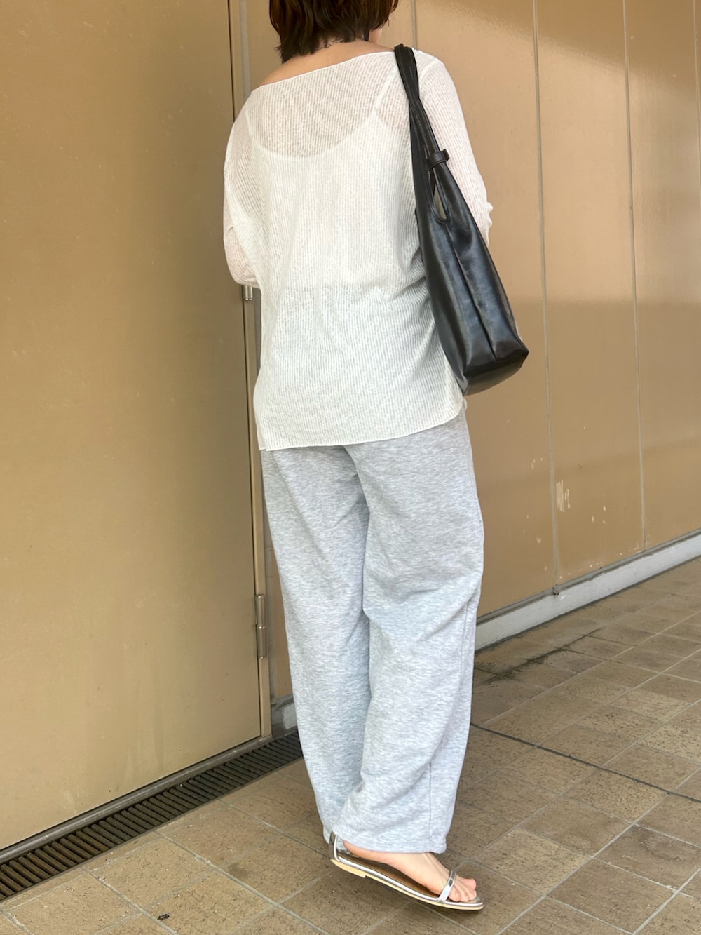 シルバー系のサンダル、ホワイト系のTシャツ/カットソー、グレー系のスウェットパンツを着用したレディースの夏コーディネートの2枚目の写真
