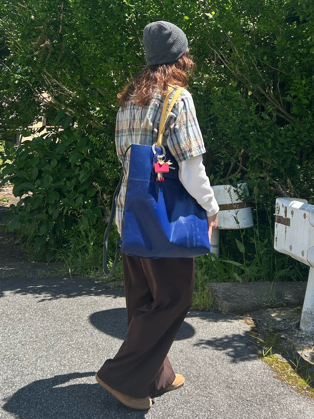 ブラウン系のスニーカー、ブルー系のシャツ/ブラウス、ホワイト系のTシャツ/カットソーを着用したレディースの春コーディネートの3枚目の写真