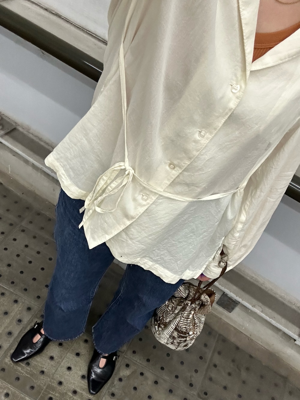 ホワイト系のシャツ/ブラウス、ブラック系のパンプス、ブラウン系のタンクトップを着用したレディースの秋コーディネートの2枚目の写真