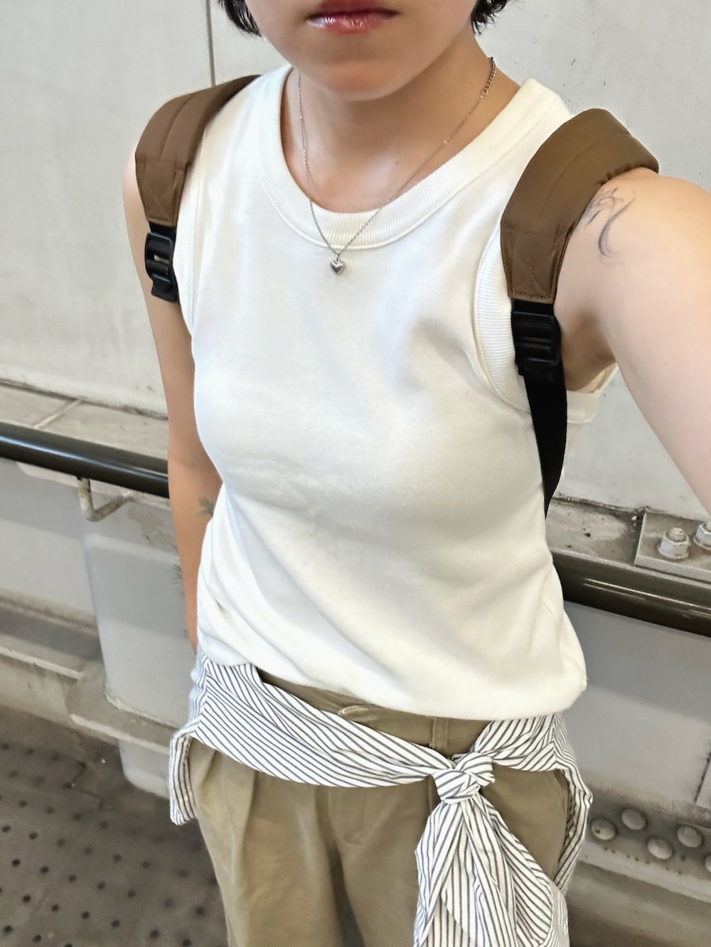 ホワイト系のタンクトップ、ベージュ系のスニーカー、ホワイト系のシャツ/ブラウスを着用したレディースの夏コーディネートの2枚目の写真