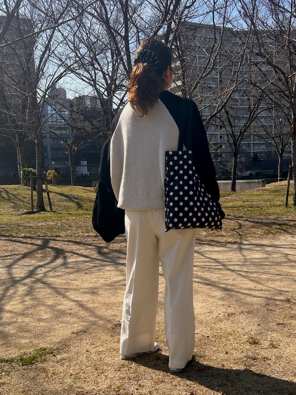 ホワイト系のスニーカー、ホワイト系のスラックス、ホワイト系のニット/セーターを着用したレディースの春コーディネートの3枚目の写真