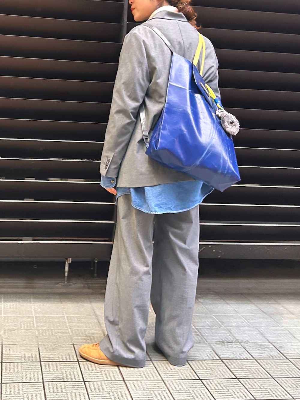 グレー系のテーラードジャケット、グレー系のスラックス、ブラウン系のスカートを着用したレディースの春コーディネートの4枚目の写真