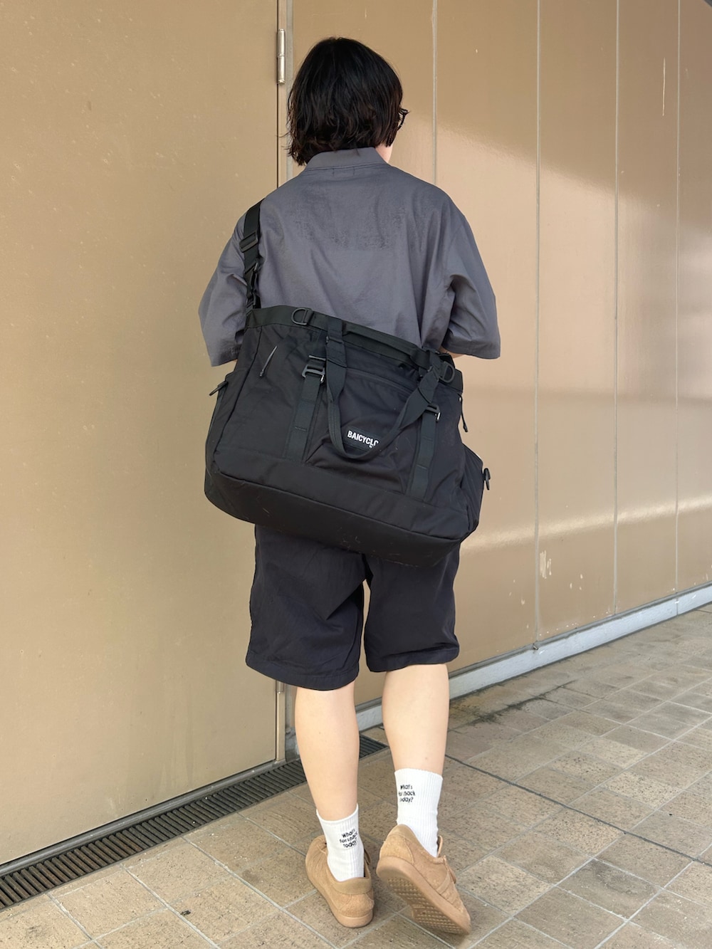 グレー系のポロシャツ、ブラウン系のスニーカー、ブラック系のトートバッグを着用したレディースの夏コーディネートの2枚目の写真