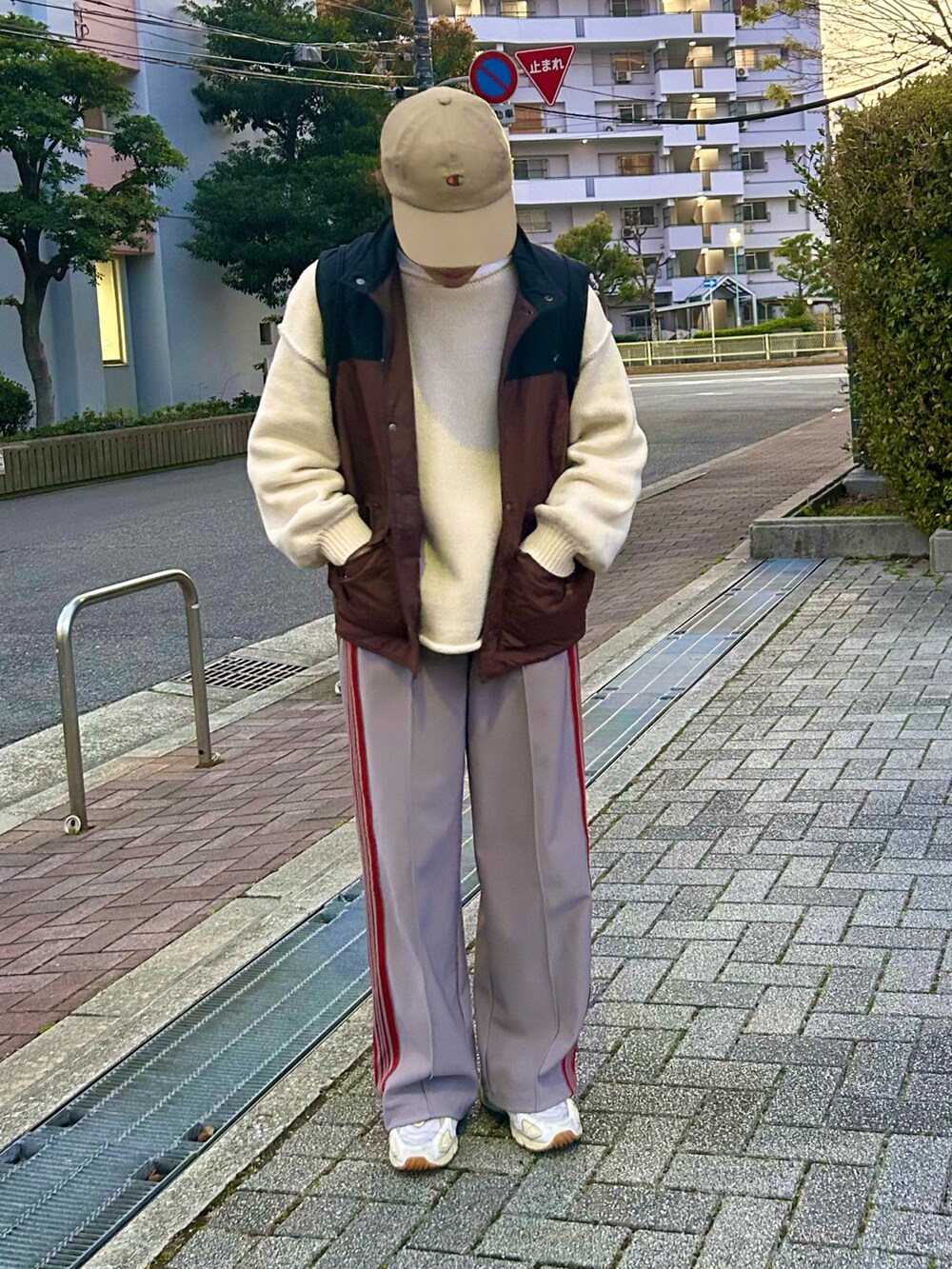 グレー系のその他パンツ、ホワイト系のニット/セーター、ベージュ系のスニーカーを着用したレディースの春コーディネートの5枚目の写真