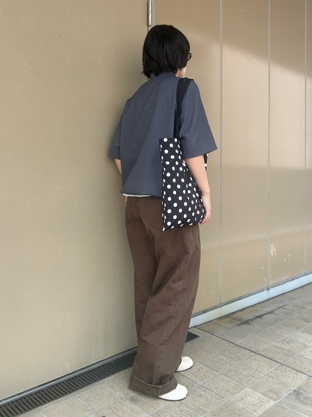 グレー系のポロシャツ、ホワイト系のTシャツ/カットソー、ブラウン系のデニムパンツを着用したレディースの夏コーディネートの2枚目の写真