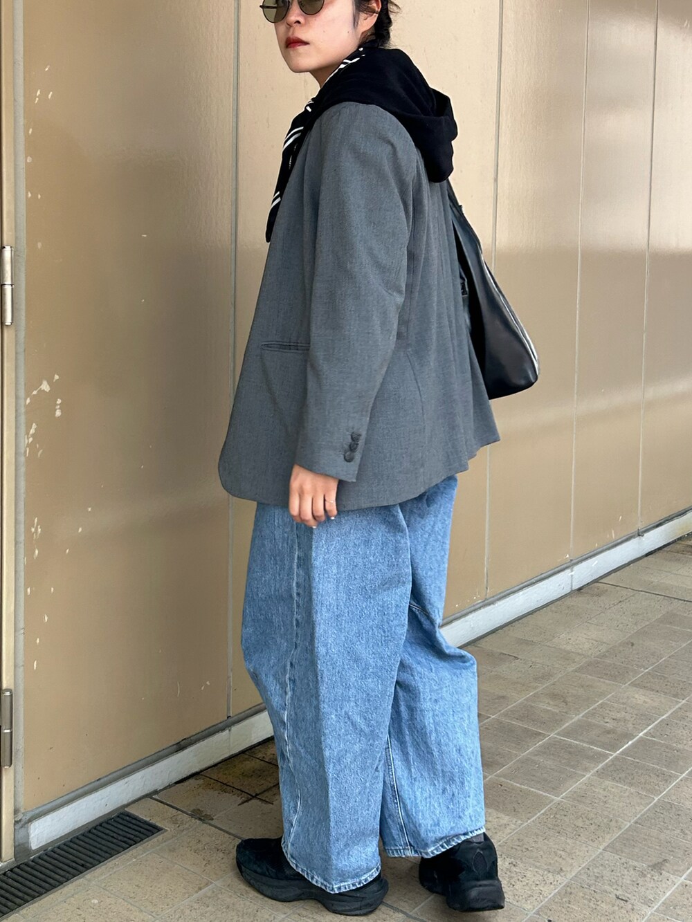 ホワイト系のTシャツ/カットソー、ブラック系のスニーカー、ブラック系のパーカーを着用したレディースの春コーディネートの4枚目の写真