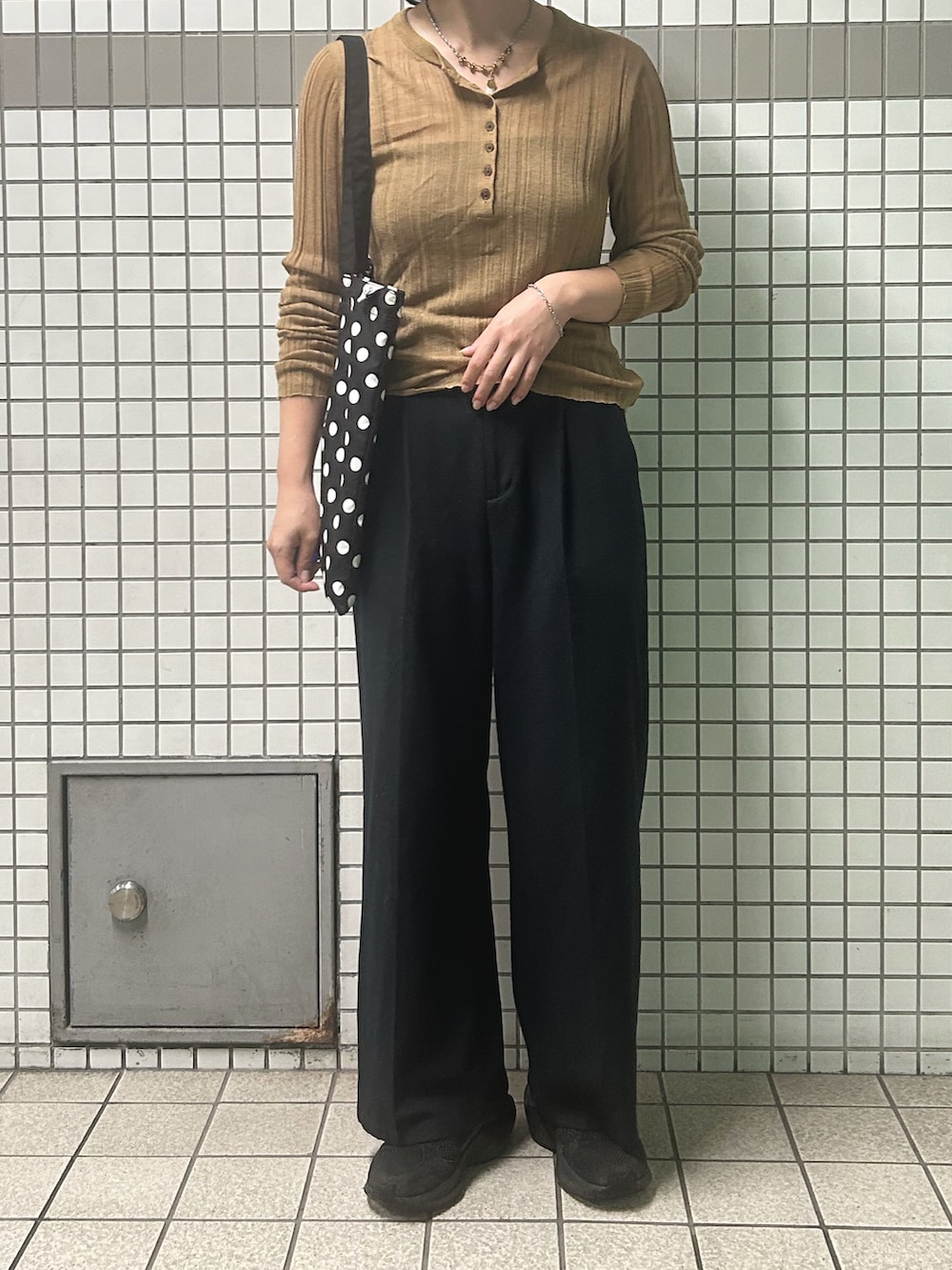 ブラック系のスニーカー、ベージュ系のTシャツ/カットソー、シルバー系のブレスレットを着用したレディースの秋コーディネートの2枚目の写真