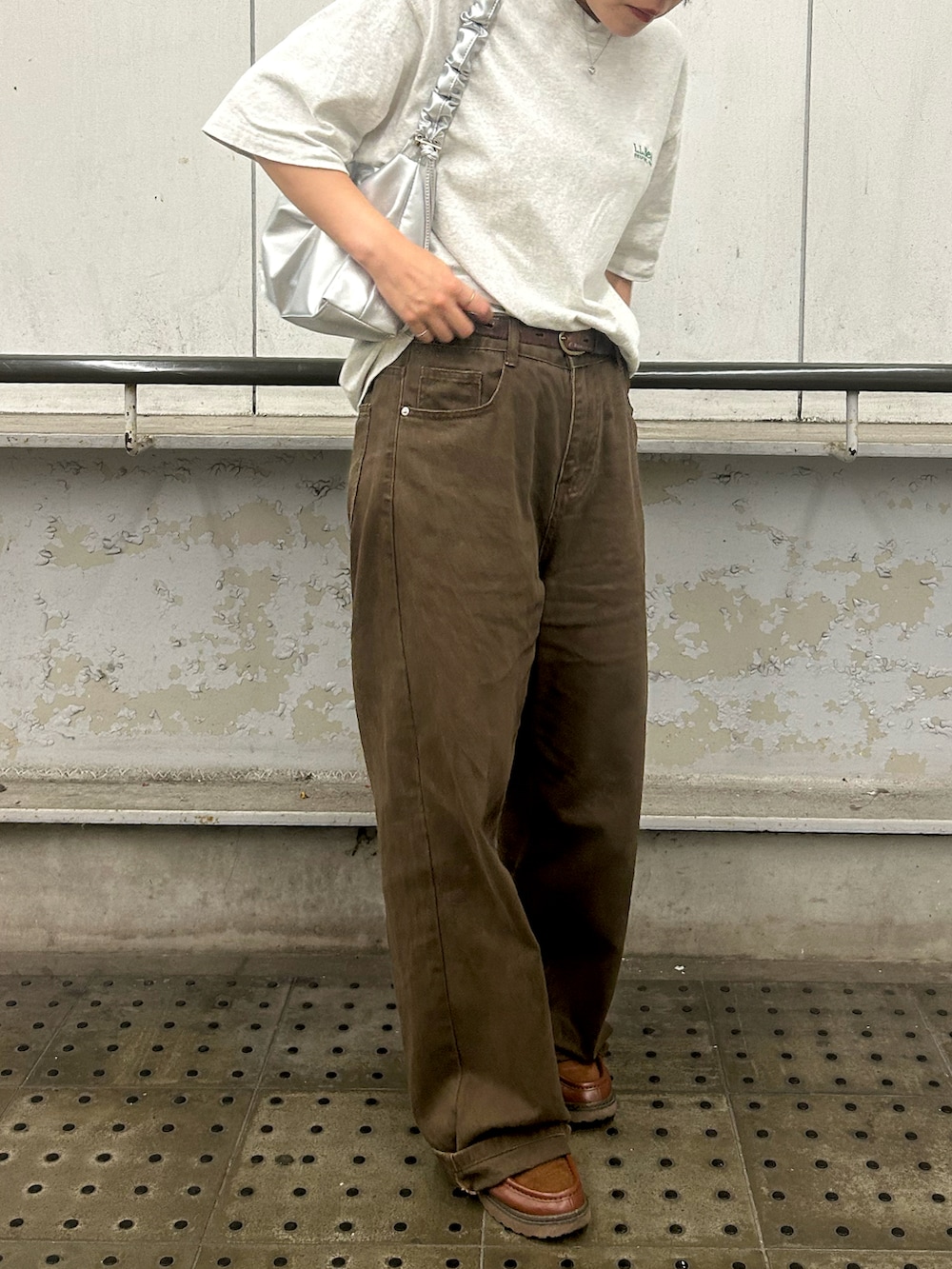 ホワイト系のTシャツ/カットソー、シルバー系のショルダーバッグ、ブラウン系のデニムパンツを着用したレディースの夏コーディネートの2枚目の写真