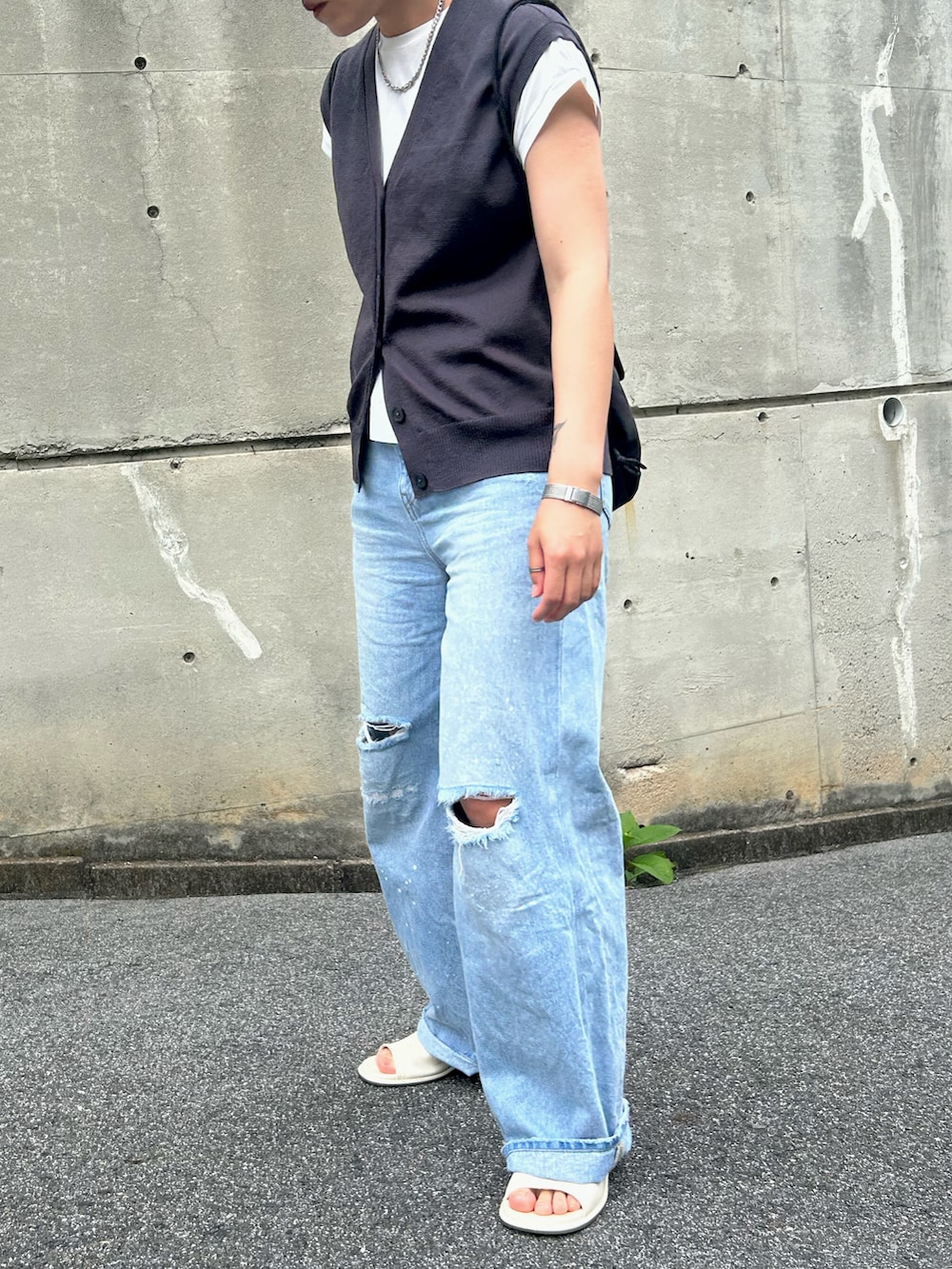 ホワイト系のTシャツ/カットソー、ブルー系のデニムパンツ、ブラック系のバックパック/リュックを着用したレディースの夏コーディネートの2枚目の写真