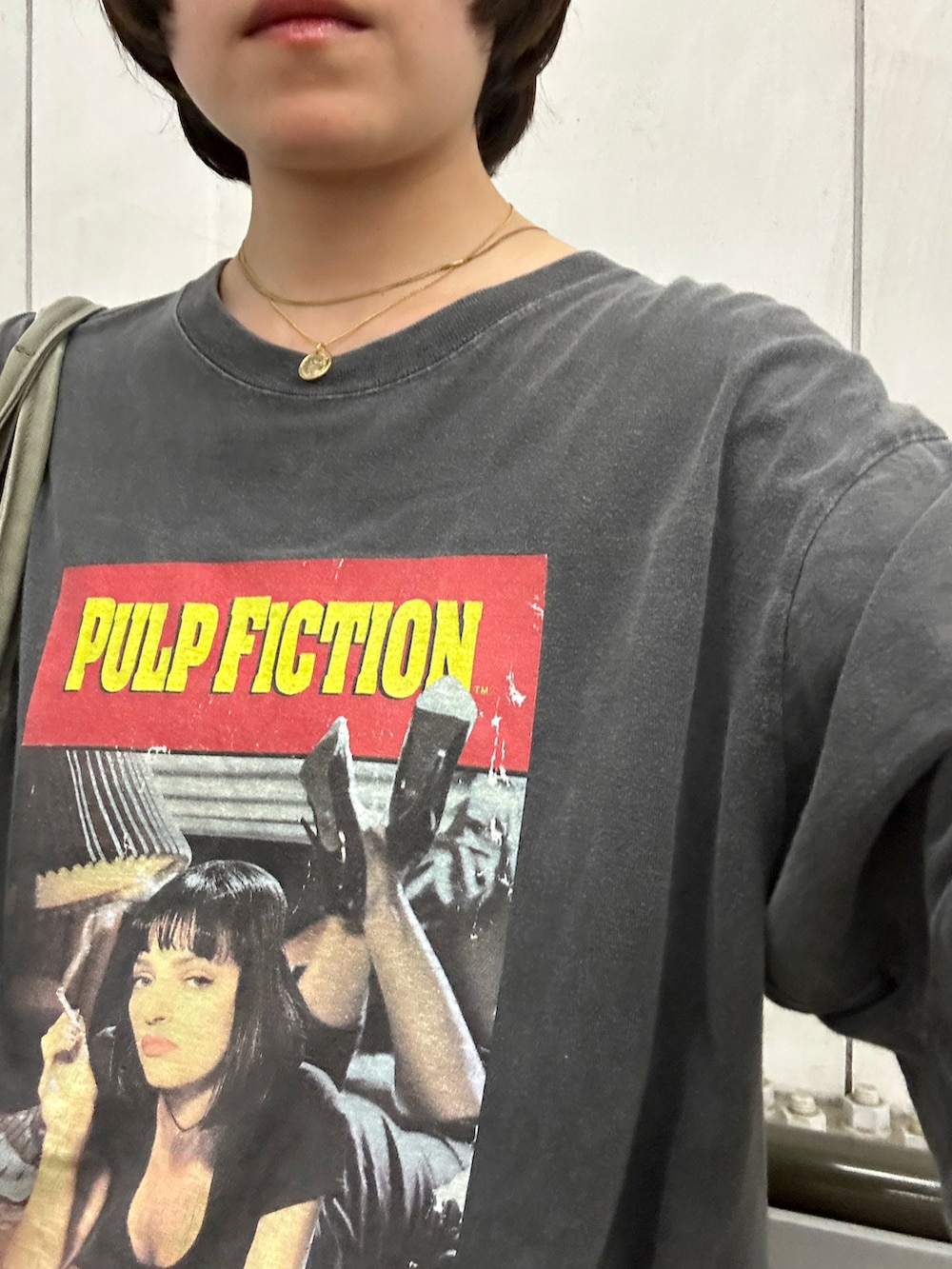 グリーン系のトートバッグ、グレー系のTシャツ/カットソー、ブラック系のスニーカーを着用したレディースの夏コーディネートの2枚目の写真