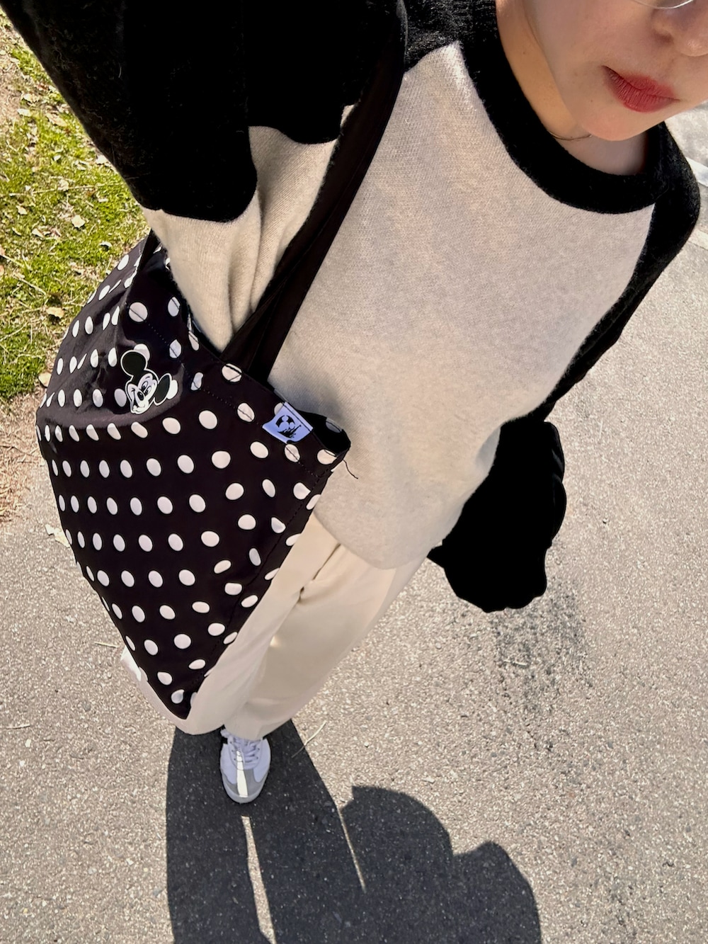 ホワイト系のスニーカー、ホワイト系のスラックス、ホワイト系のニット/セーターを着用したレディースの春コーディネートの5枚目の写真