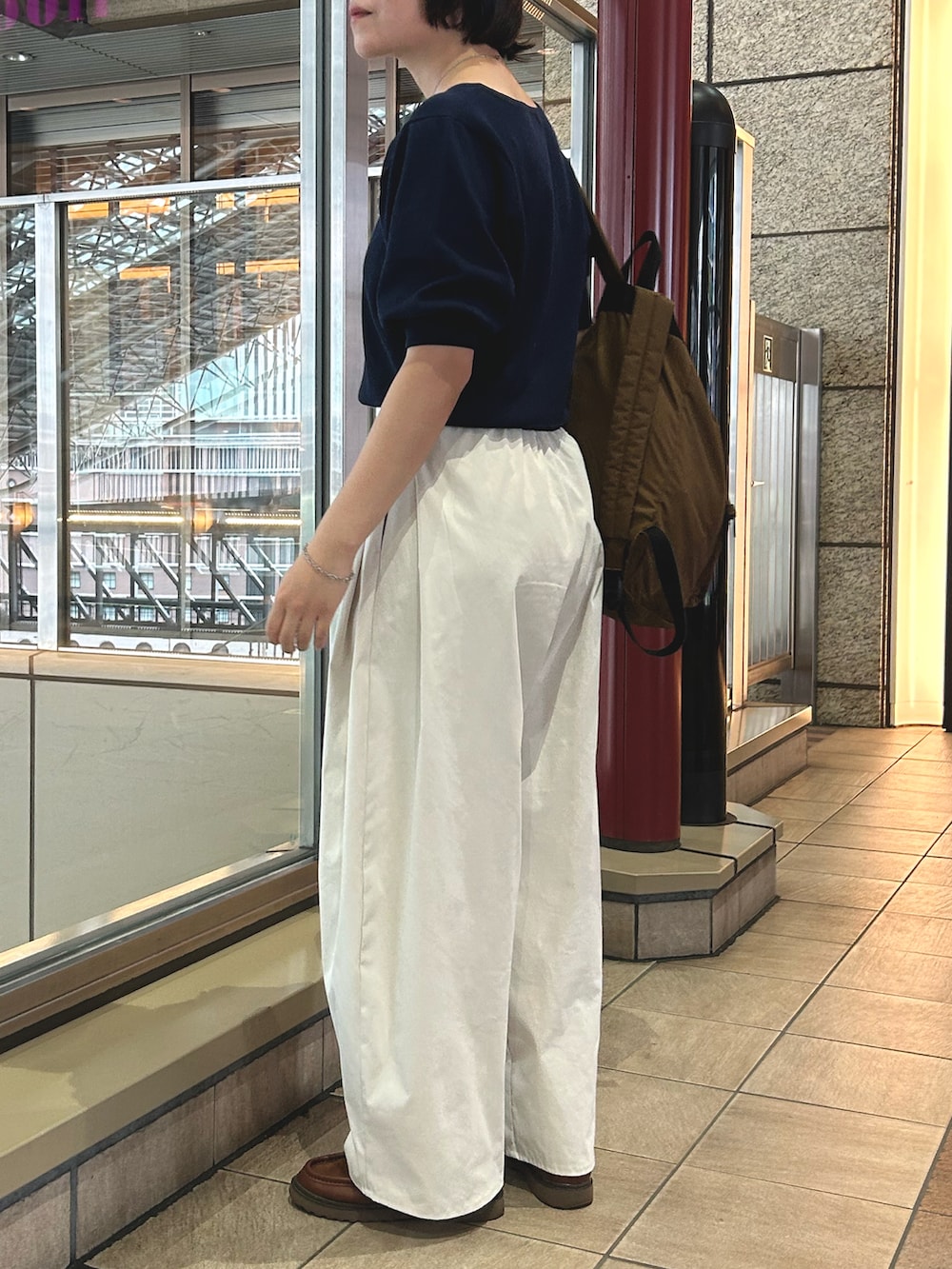 ホワイト系のその他パンツ、ブルー系のニット/セーター、ブラウン系のバックパック/リュックを着用したレディースの秋コーディネートの2枚目の写真