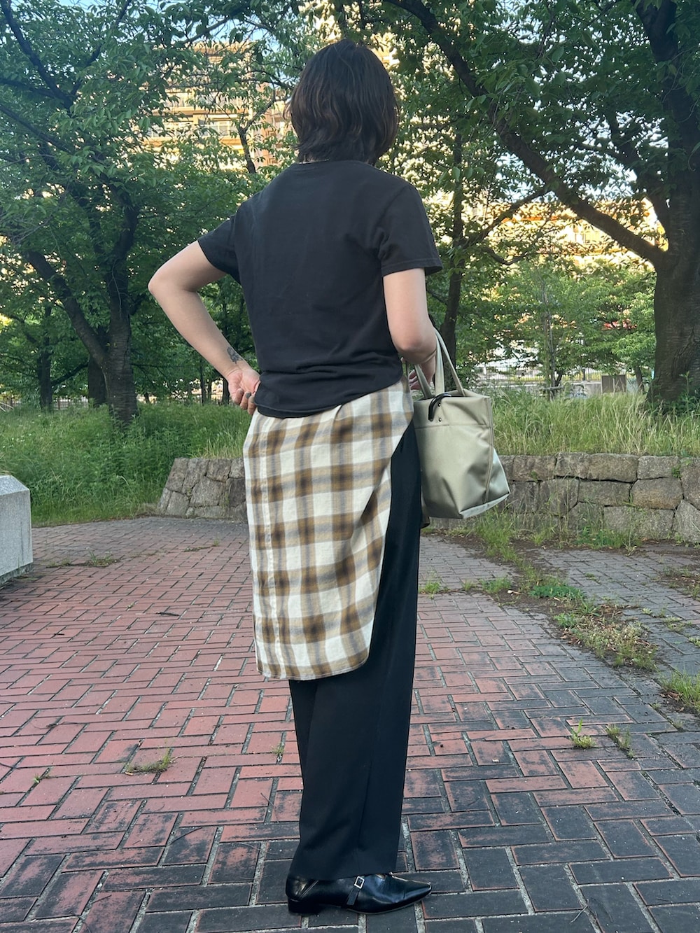 ブラック系のパンプス、ブラウン系のシャツ/ブラウス、ブラック系のTシャツ/カットソーを着用したレディースの春コーディネートの2枚目の写真