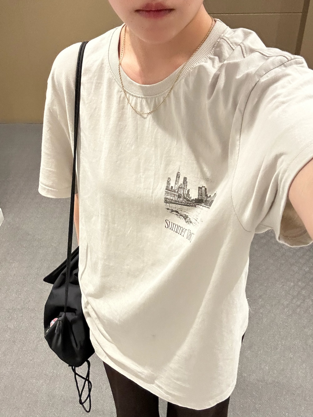 ブラック系のバックパック/リュック、ブラック系のサンダル、ベージュ系のTシャツ/カットソーを着用したレディースの夏コーディネートの2枚目の写真