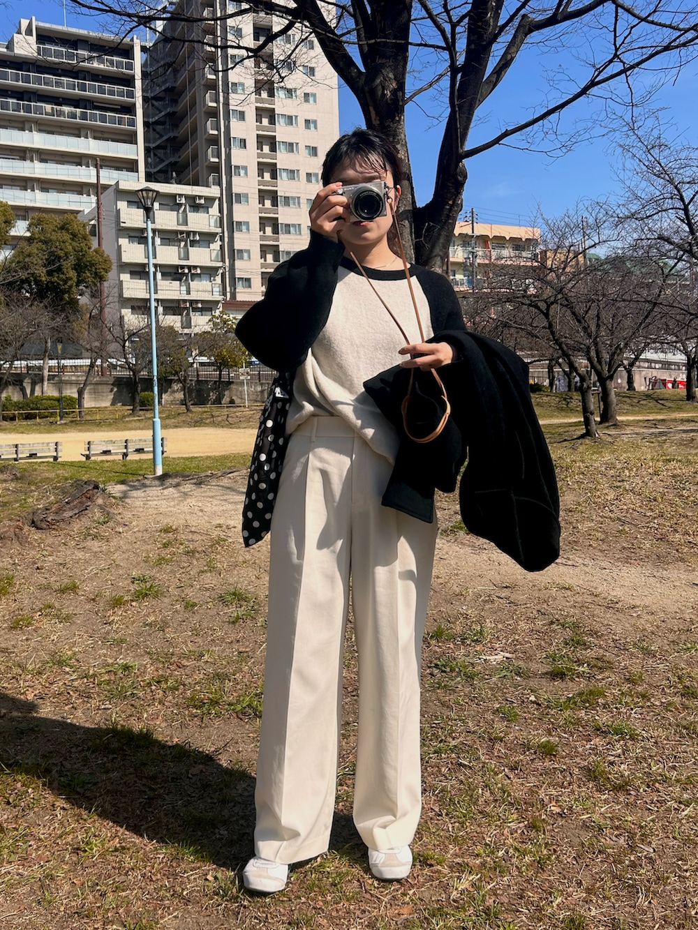 ホワイト系のスニーカー、ホワイト系のスラックス、ホワイト系のニット/セーターを着用したレディースの春コーディネートの4枚目の写真