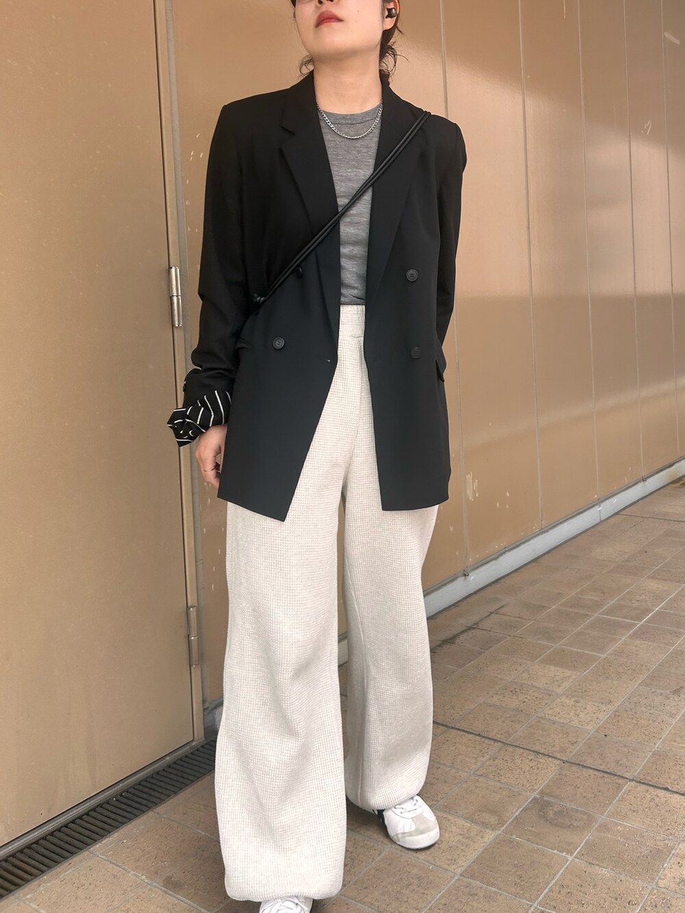ホワイト系のスニーカー、グレー系のTシャツ/カットソー、ブラック系のテーラードジャケットを着用したレディースの春コーディネートの4枚目の写真