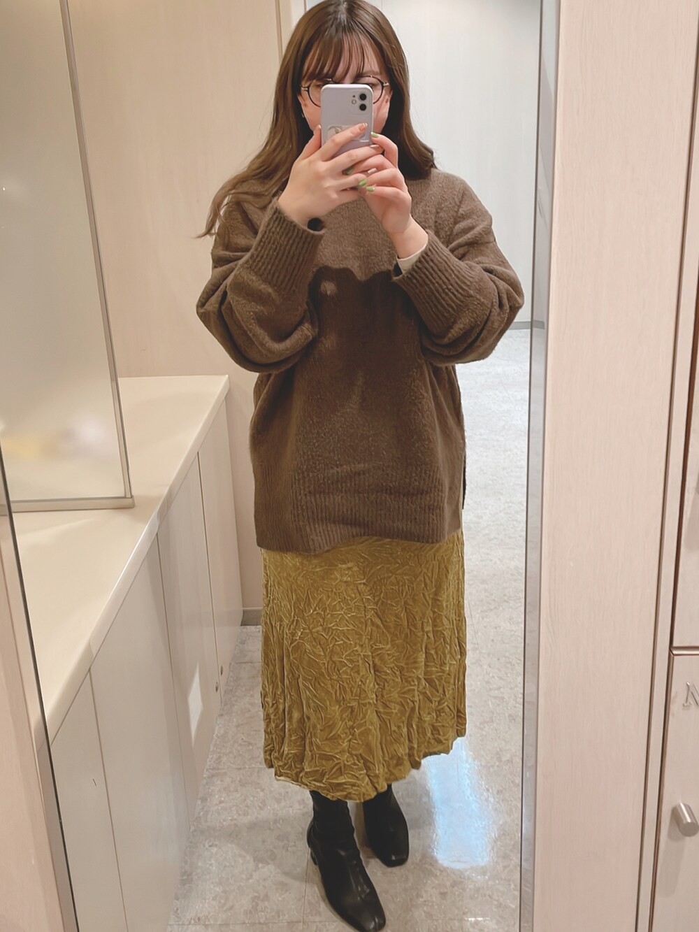 イエロー系のスカート、ブラック系のトートバッグ、ブラウン系のニット/セーターを着用したレディースの冬コーディネートの2枚目の写真