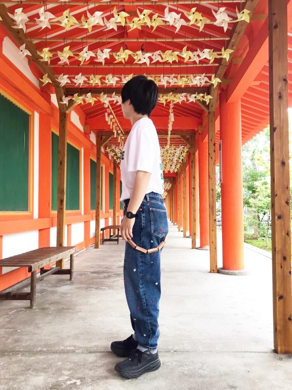 ホワイト系のTシャツ/カットソー、ブルー系のデニムパンツ、ブラック系のスニーカーを着用したレディースの秋コーディネートの2枚目の写真