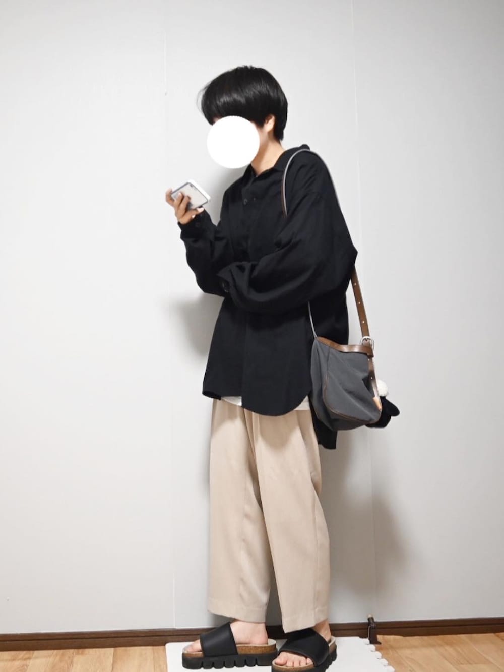ホワイト系のTシャツ/カットソー、ブラック系のシャツ/ブラウス、ベージュ系のスラックスを着用したレディースの夏コーディネートの2枚目の写真