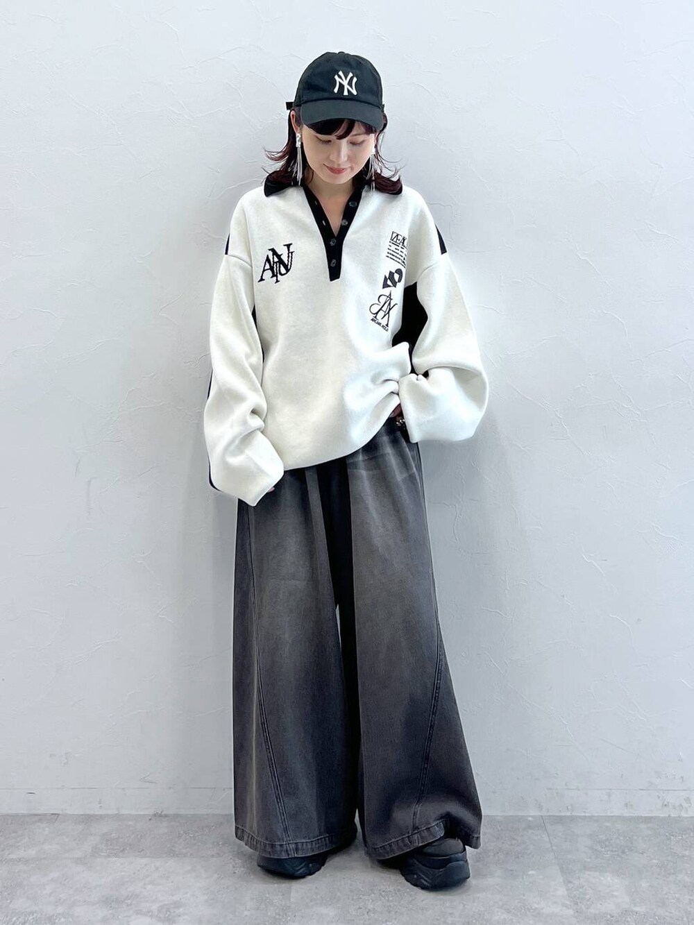 ブラック系のデニムパンツ、ブラック系のニット/セーター、ブラック系のスニーカーを着用したレディースの秋コーディネートの3枚目の写真