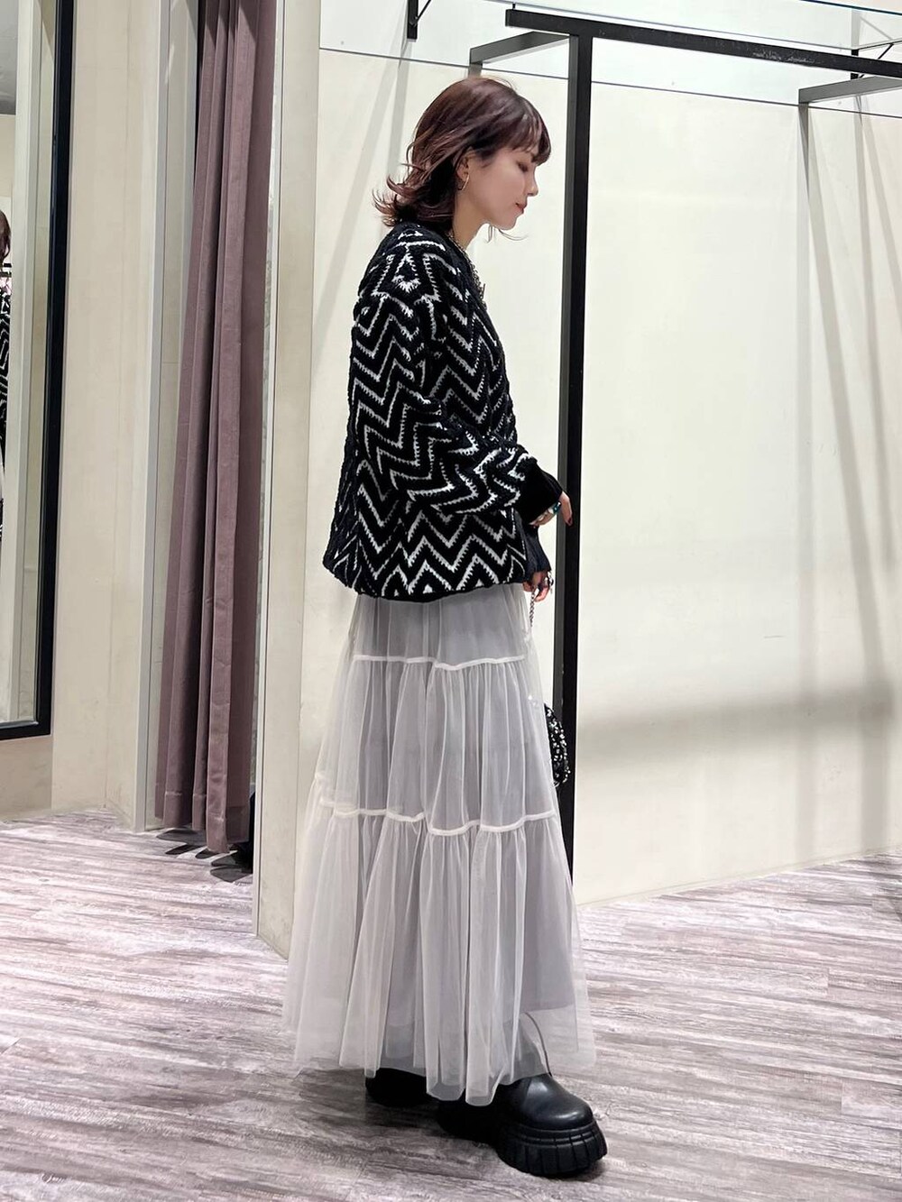 ブラック系のブーツ、シルバー系のショルダーバッグ、ブラック系のニット/セーターを着用したレディースの冬コーディネートの3枚目の写真