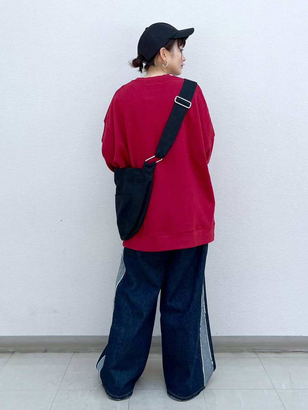 ブラック系のブーツ、ブラック系のショルダーバッグ、レッド系のスウェットを着用したレディースの秋コーディネートの3枚目の写真