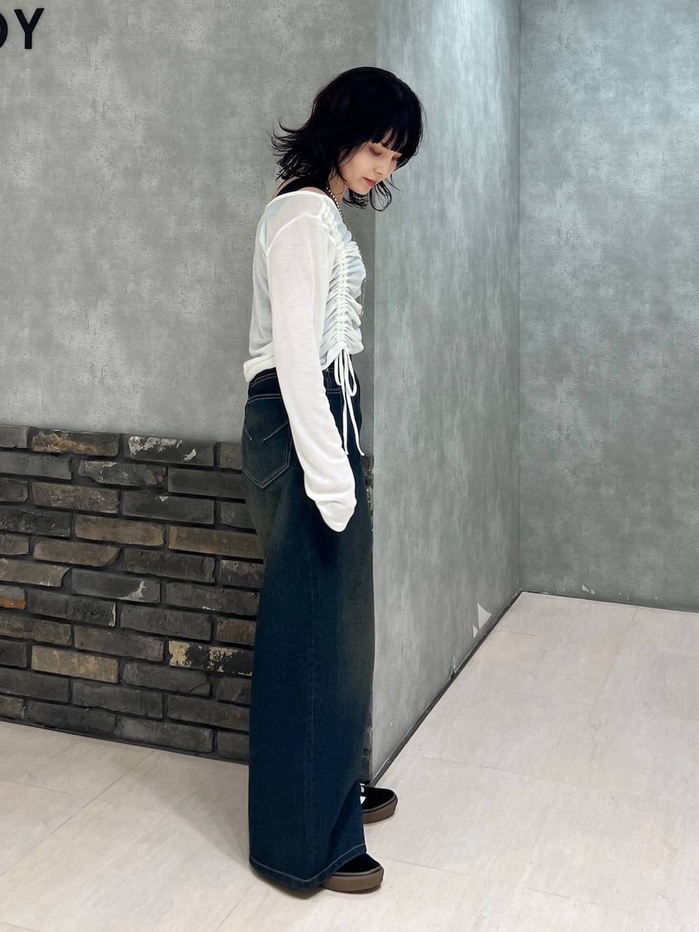 ブルー系のデニムパンツ、ブラック系のタンクトップ、ホワイト系のTシャツ/カットソーを着用したレディースの春コーディネートの3枚目の写真