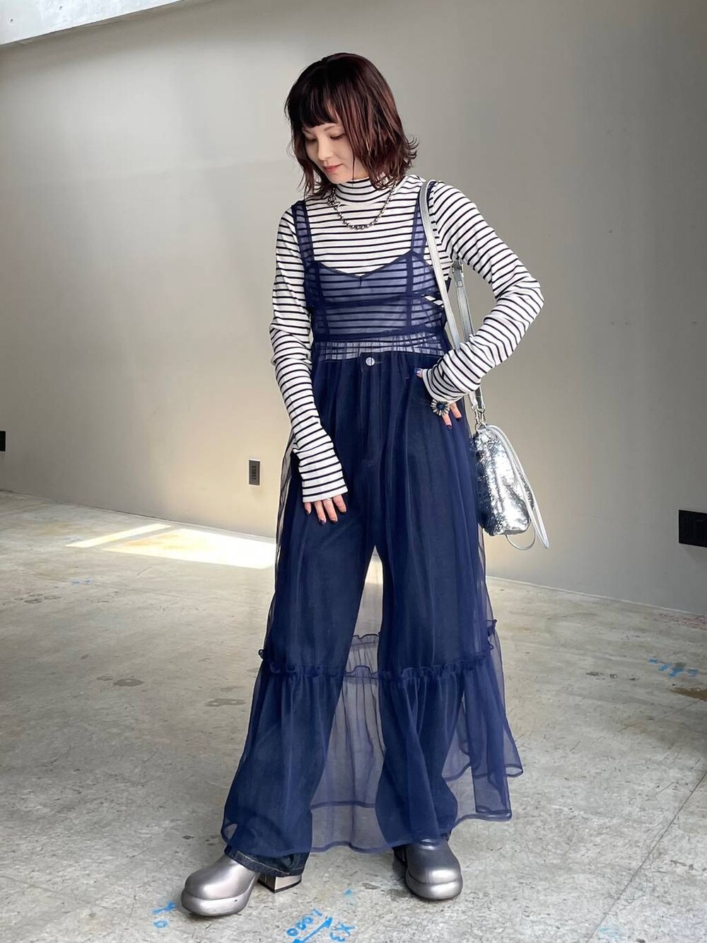 ブルー系のデニムパンツ、その他のブーツ、ブルー系のワンピースを着用したレディースの秋コーディネートの2枚目の写真