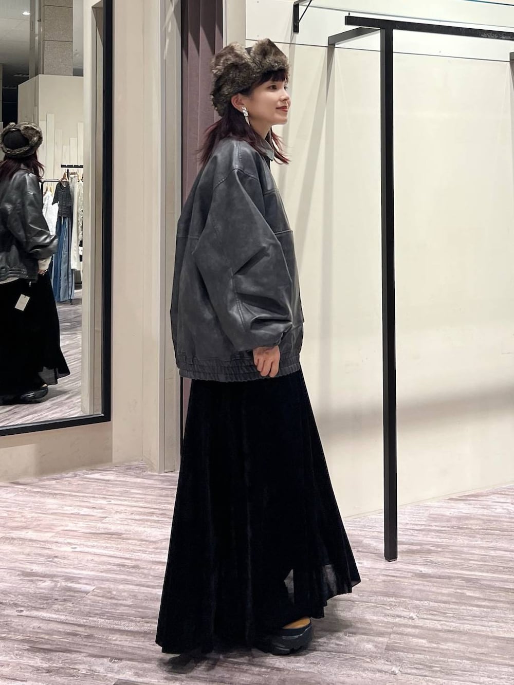 ブラック系のデニムパンツ、ブラウン系のブーツ、グレー系のブルゾンを着用したレディースの秋コーディネートの3枚目の写真