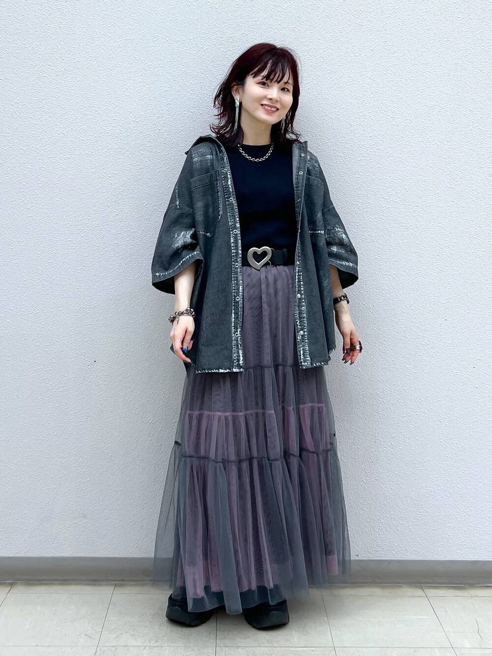 ブラック系のスニーカー、グレー系のスカート、ブラック系のシャツ/ブラウスを着用したレディースの夏コーディネートの2枚目の写真