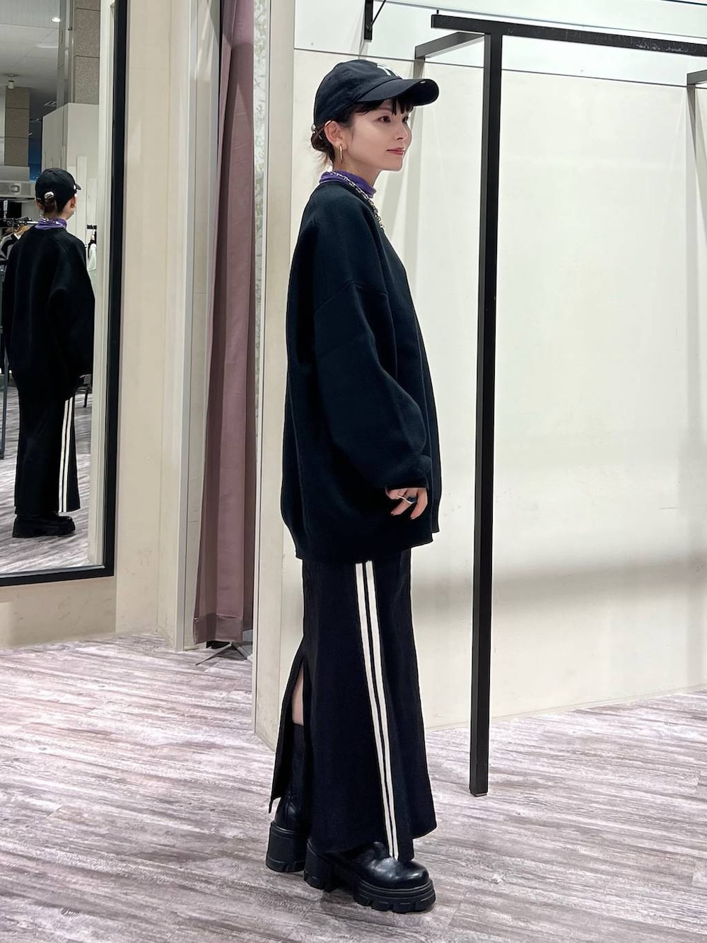 ブラック系のニット/セーター、パープル系のTシャツ/カットソー、ブラック系のスニーカーを着用したレディースの冬コーディネートの3枚目の写真