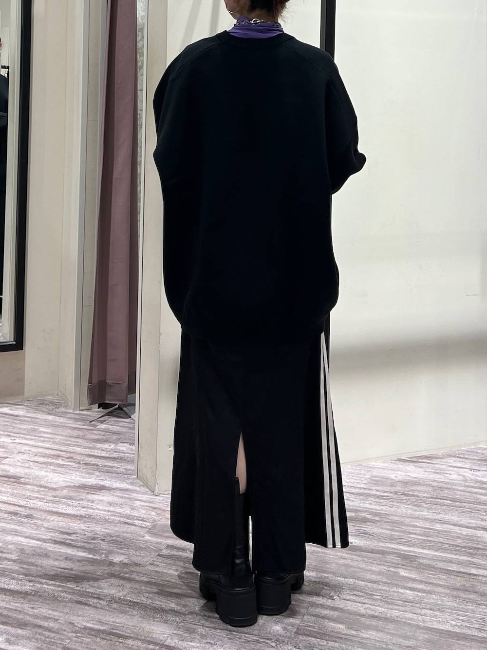 ブラック系のニット/セーター、パープル系のTシャツ/カットソー、ブラック系のスニーカーを着用したレディースの冬コーディネートの5枚目の写真